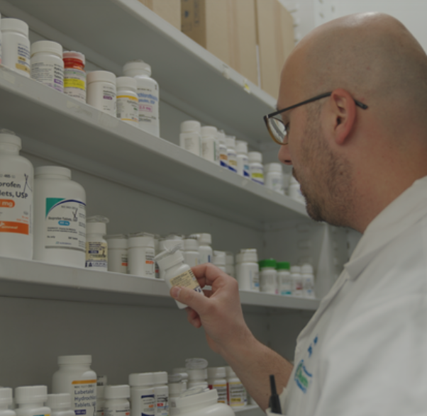Westmont Pharmacy pharmacist checking a compounded medication against the pharmacy shelf